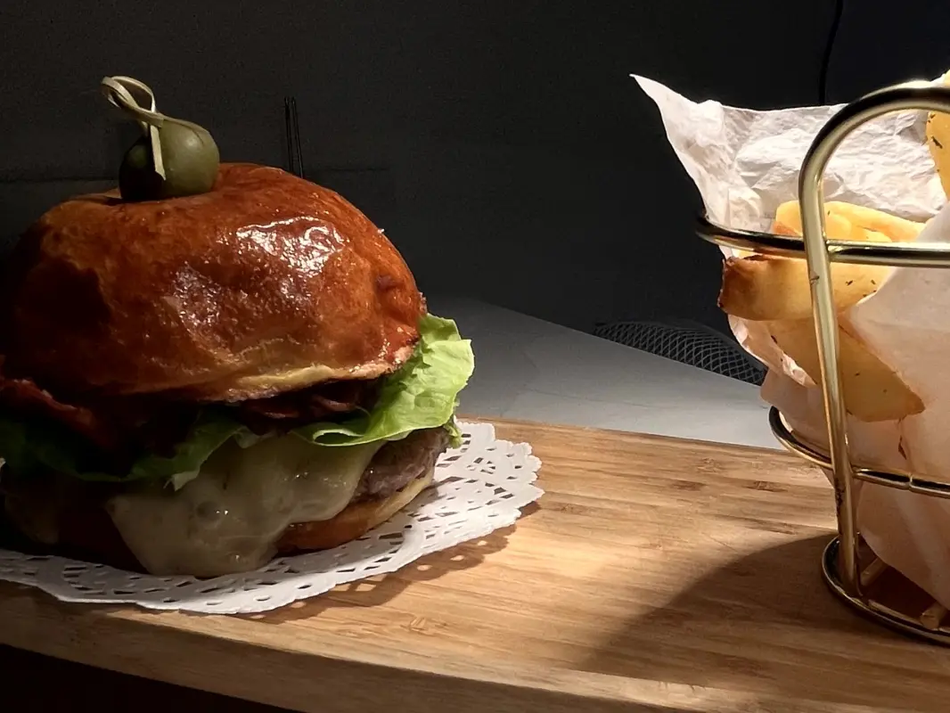 Hamburguesa gourmet de res acompañada de papas a la francesa.