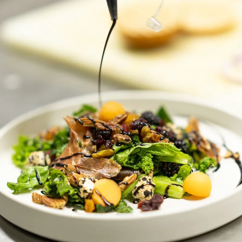 Ensalada fresca con nueces, arándanos y aderezo.
